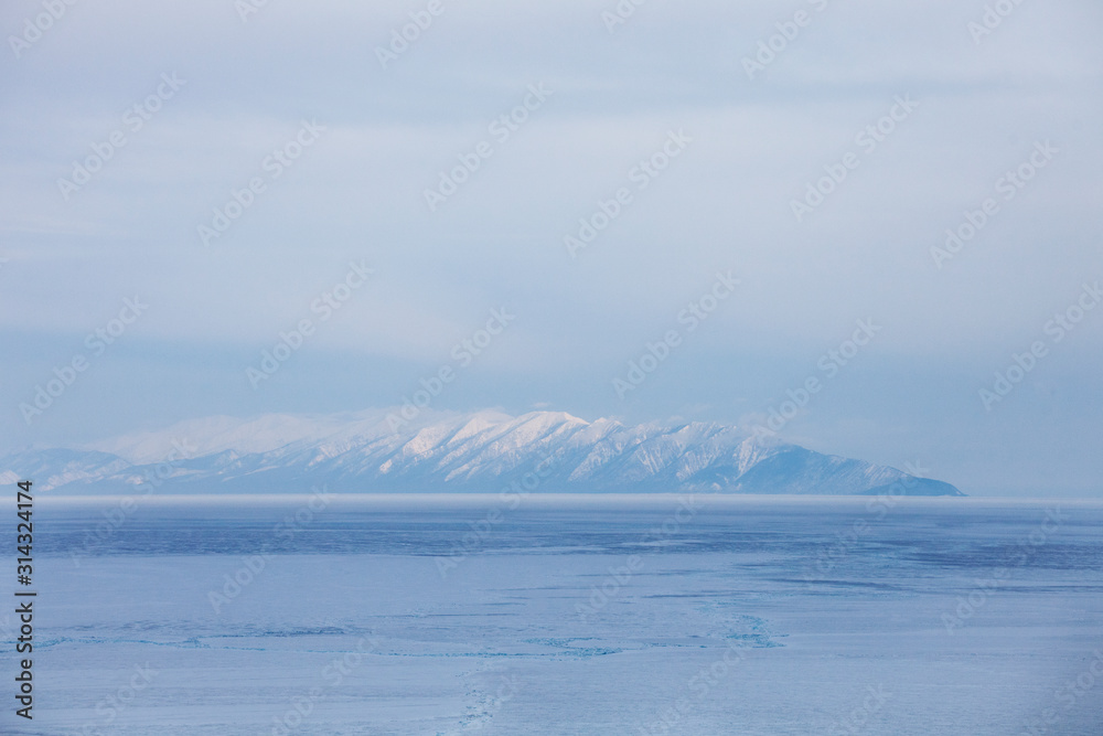 Baikal lake. Snowy mountain peaks, winter landscape.