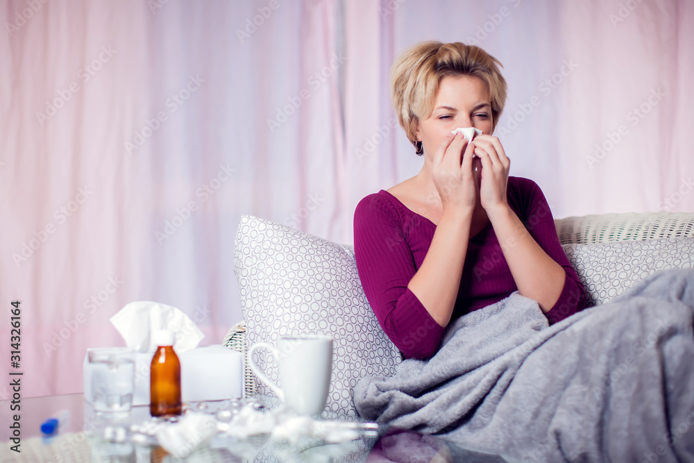 Woman got the flu, blowing nose into napkin. People, healthcare and medicine concept