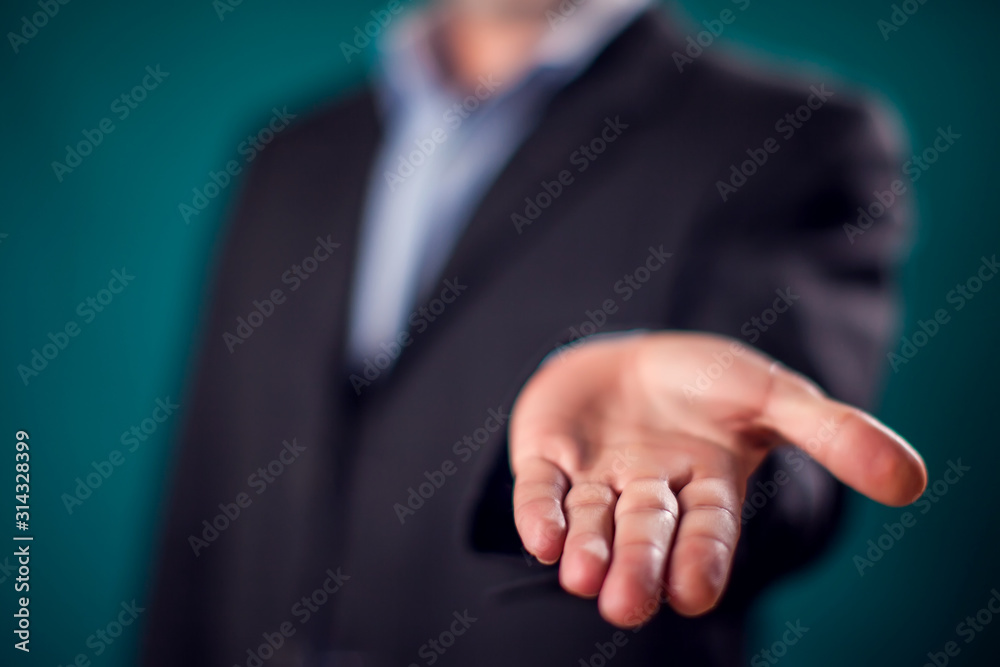 Businessman in suit showing hand offering something