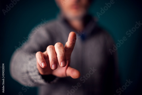 Businessman in suit pressing virtual button or pointing at something photo