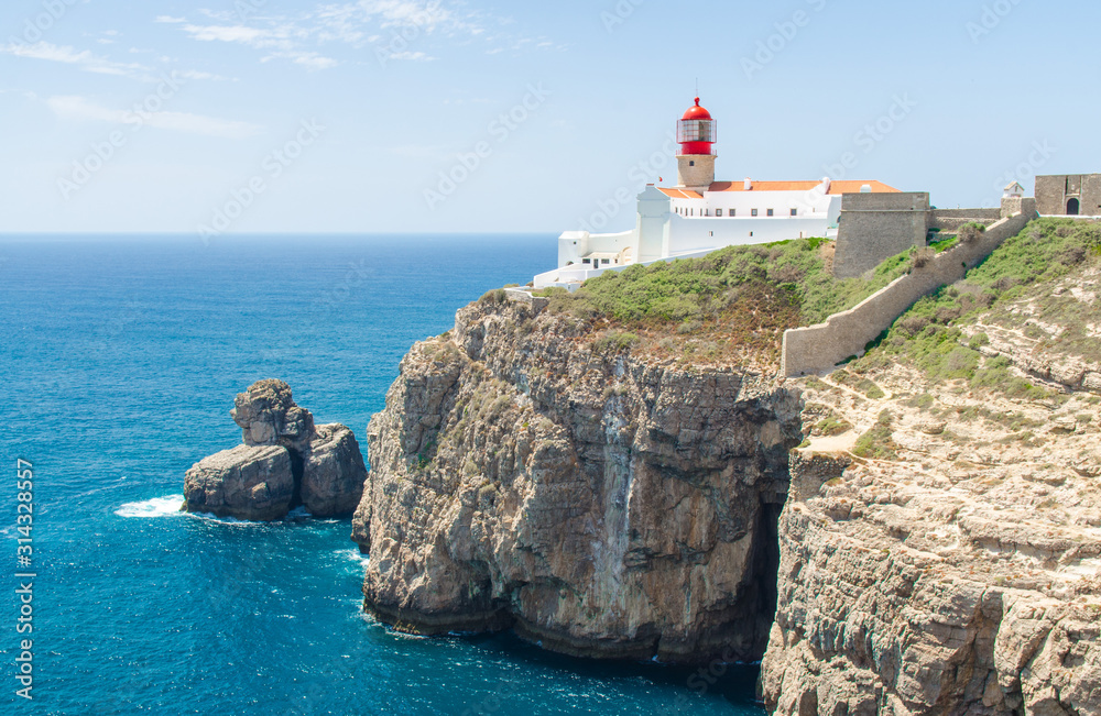 Portugal, Algarve, view of cliffs of Moher and Atlantic Ocean, white red lighthouse, lighthouse near Sagres in Portugal, Cape St. Vincent on a sunny day with The azure Atlantic  in the background