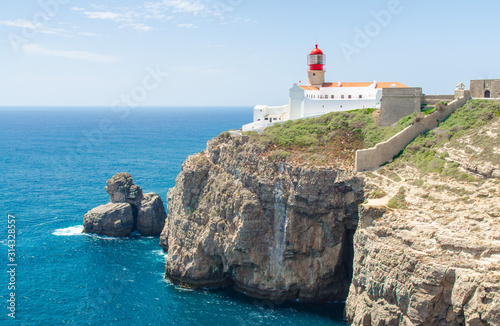 Portugal, Algarve, view of cliffs of Moher and Atlantic Ocean, white red lighthouse, lighthouse near Sagres in Portugal, Cape St. Vincent on a sunny day with The azure Atlantic  in the background photo
