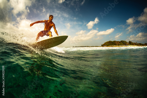 Surfer rides the ocean wave in tropics.