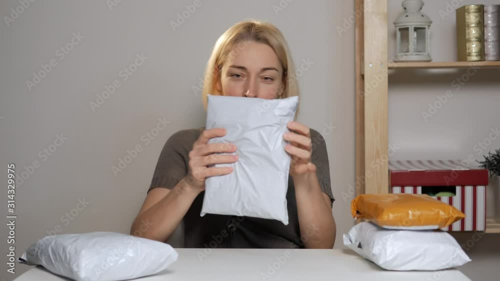 Female blogger sitting at a table studying a purchase with the online store. Female blogger sitting at a table studying a purchase with the online store.