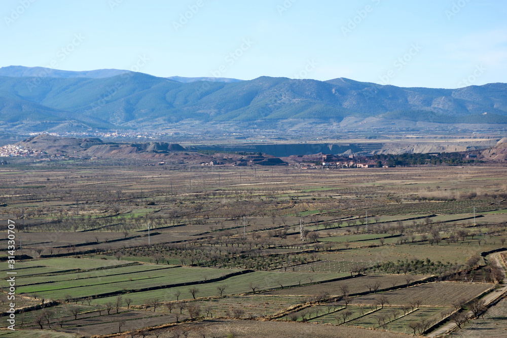 landscape with valley full of fields in sierra nevada mountains and blue sky