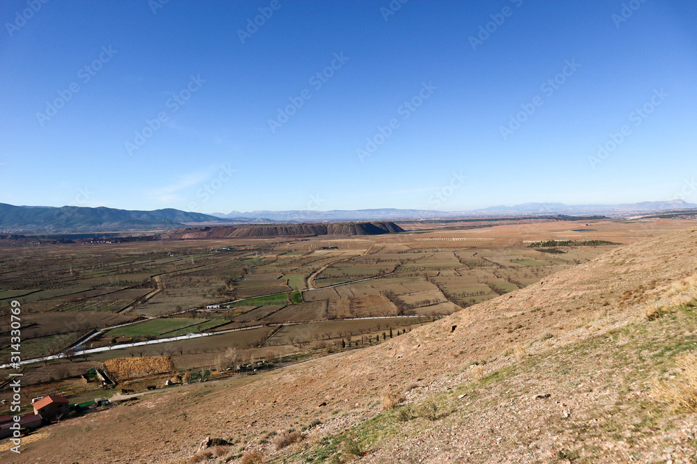 Obraz premium landscape with valley full of fields in sierra nevada mountains and blue sky