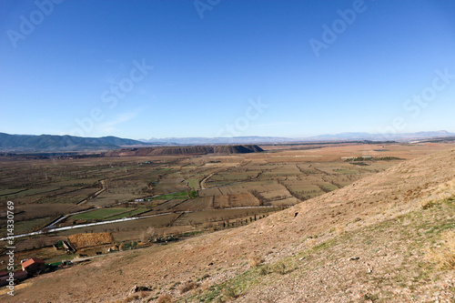 landscape with valley full of fields in sierra nevada mountains and blue sky