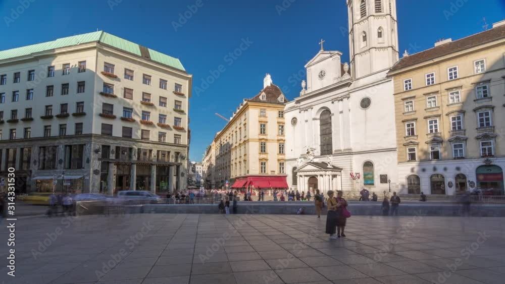 St. Michael's Church timelapse hyperlapse (Michaelerkirche), the church dedicated to Archangel Michael at Michaelerplatz (St. Michael's Square) across from St. Michael's Gate of Hofburg. People St. Michael's Church timelapse hyperlapse (Michaelerkirche), the church dedicated to Archangel Michael at Michaelerplatz (St. Michael's Square) across from St. Michael's Gate of Hofburg. People