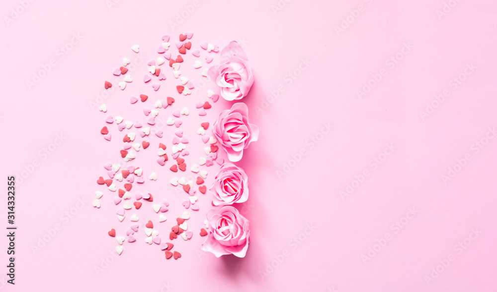 Valentines Day. Heart shape formed of sweet confetti on pink background with rose flower. Template mock up of greeting card or text design Valentines Day. Heart shape formed of sweet confetti on pink background with rose flower. Template mock up of greeting card or text design