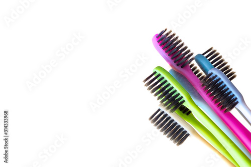 multi-colored toothbrushes with black bristles on a white background.
