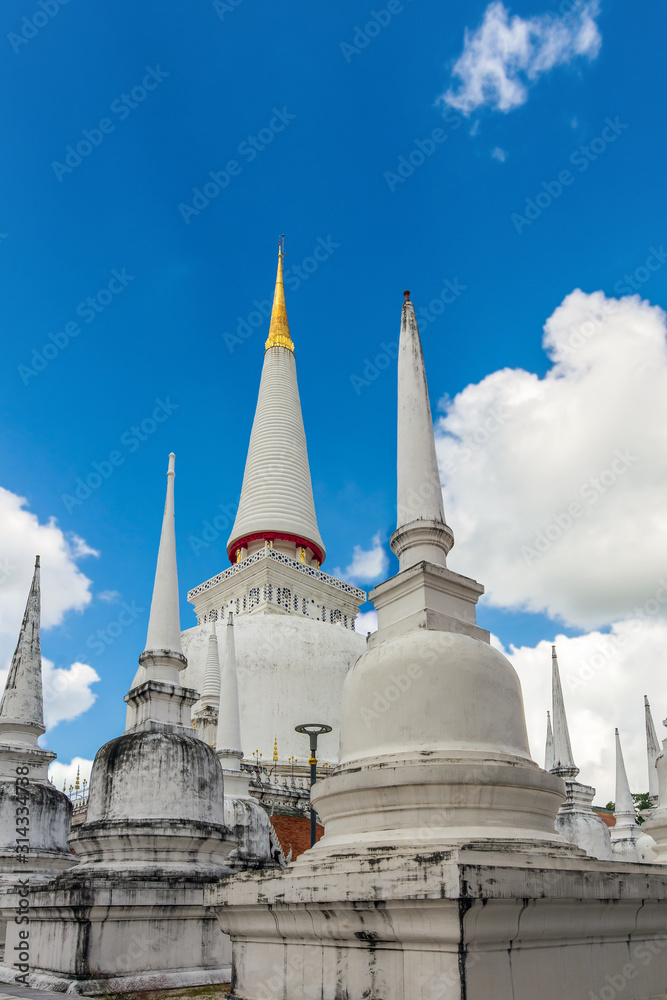 Beautiful white pagodas with blue sky and white clouds background, Wat Phra Mahathat Woramahawihan  is the most important temple in South of Thailand.