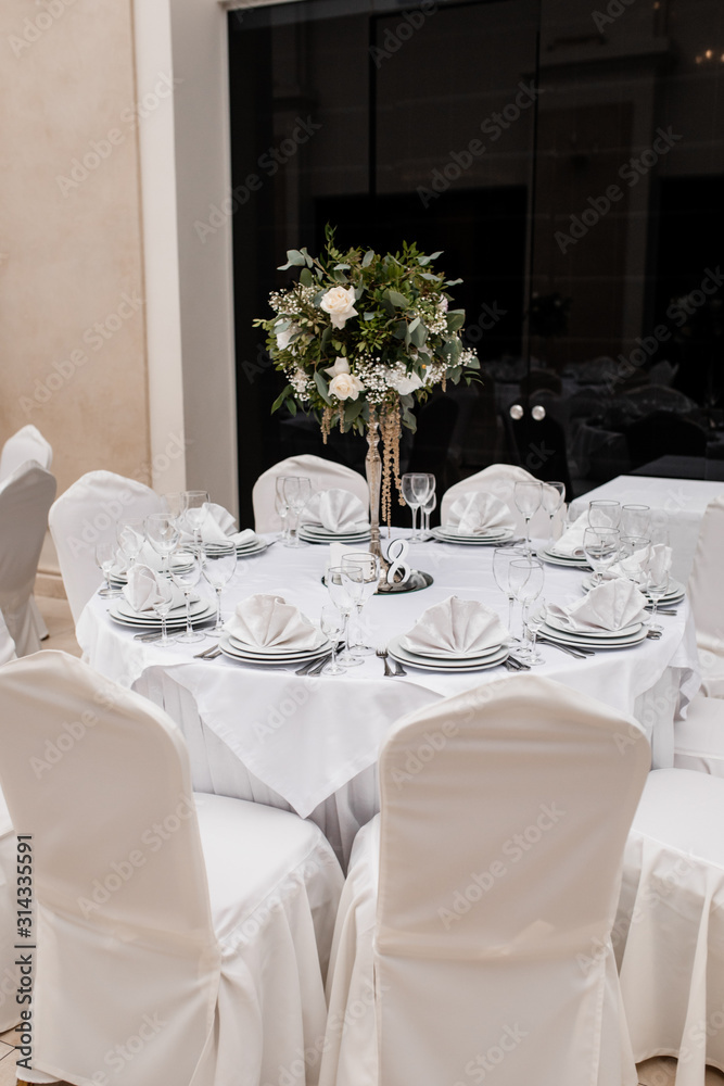 White table serving with white chairs and a floral centerpiece White table serving with white chairs and a floral centerpiece