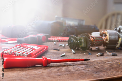 Details of electrical appliance and repair tools on a wooden table in a repair shop