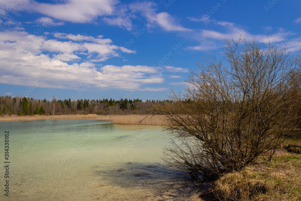 A lake in Russia with very clear azure water. Spring landscape with lake and blue sky.