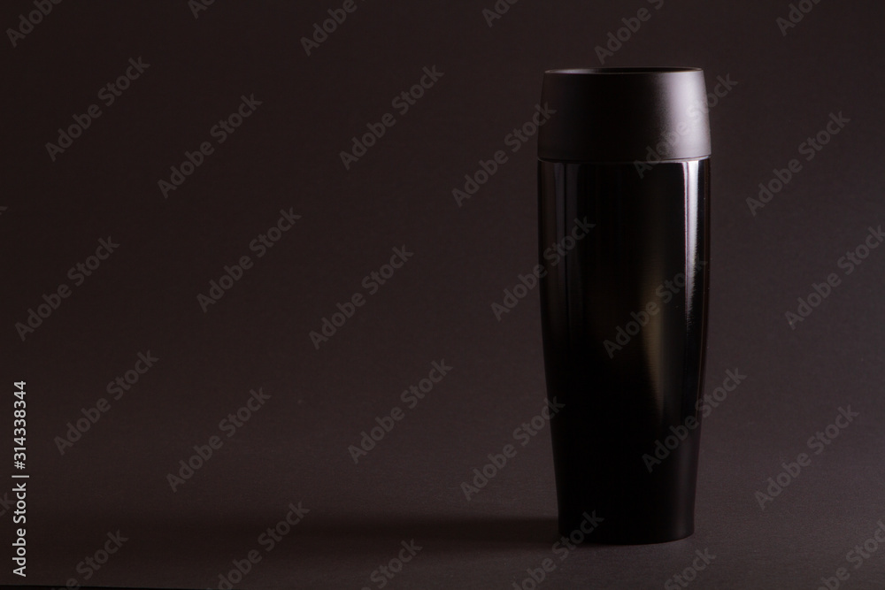 one black thermal bottle shaker for sports nutrition on a black background. one black thermal bottle shaker for sports nutrition on a black background.