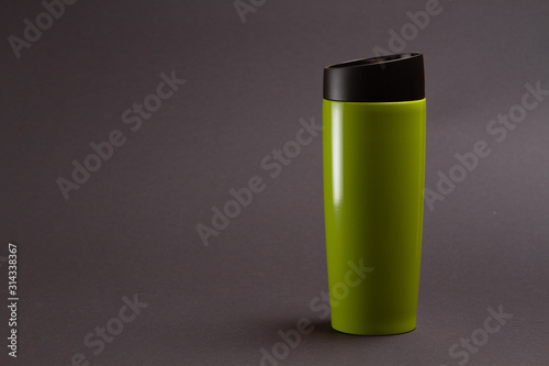 one green thermal bottle shaker for sports nutrition on a black background.