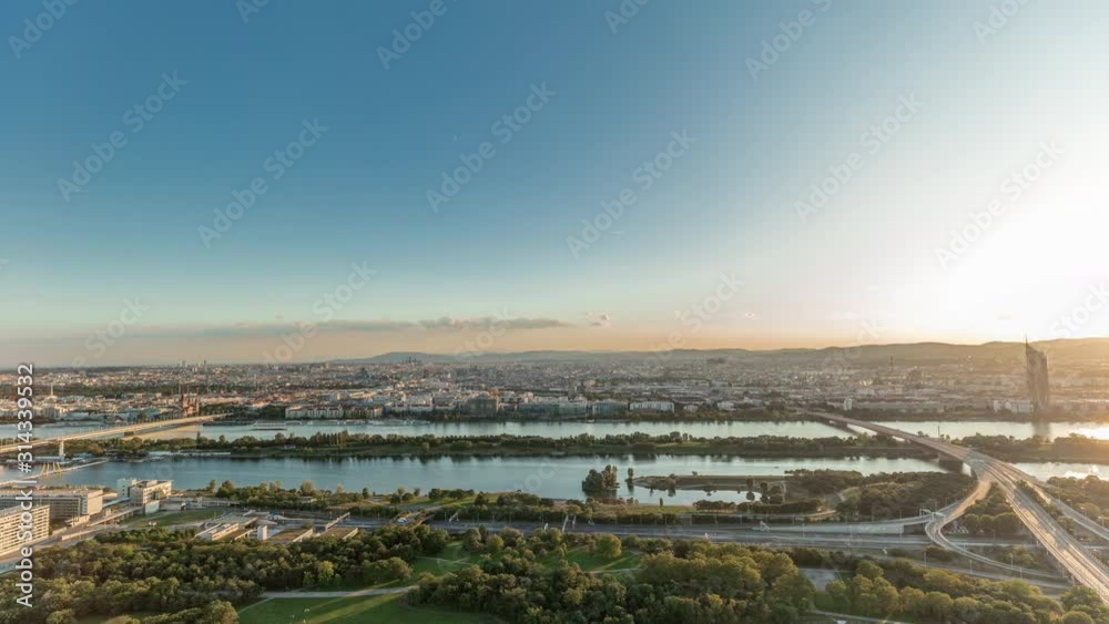 Aerial panoramic view of Vienna city with highway intersection, historic buildings and a riverside promenade timelapse in Austria. Evening skyline before sunset from Danube Tower viewpoint Aerial panoramic view of Vienna city with highway intersection, historic buildings and a riverside promenade timelapse in Austria. Evening skyline before sunset from Danube Tower viewpoint