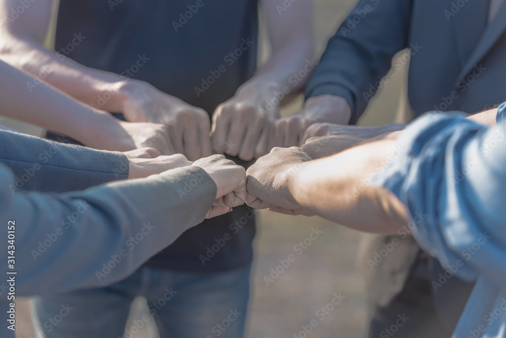 Teamwork expression of people putting hands together.