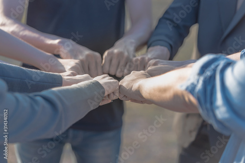 Teamwork expression of people putting hands together.
