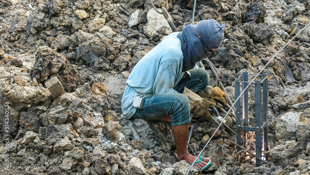welder worker male sit down welding steel for make foundation piles in pit welder worker male sit down welding steel for make foundation piles in pit