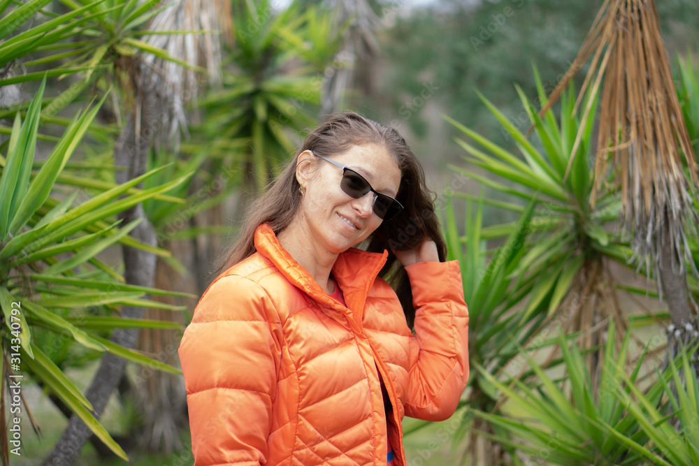 Woman smiling near palms in the park Woman smiling near palms in the park
