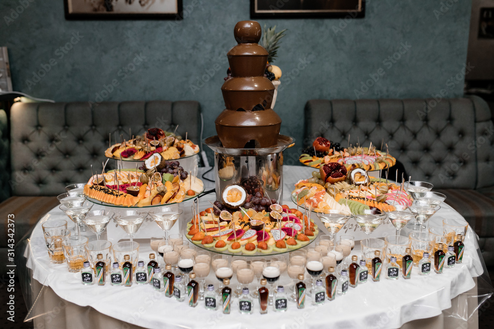 Alcohol buffet with fruits and chocolate fountain at the party Stock Photo  | Adobe Stock