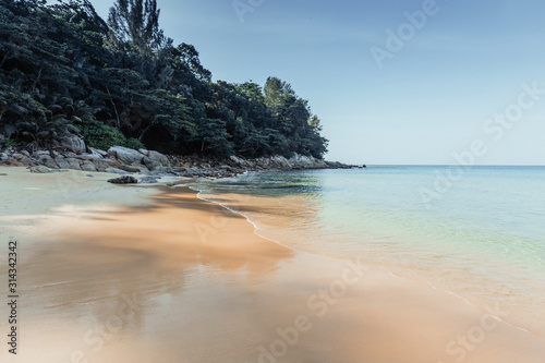 Fototapeta Naklejka Na Ścianę i Meble -  ?lear blue sea and beach with palm trees. View from the sea to the Thailand beach, large stones on the shore and clean sand