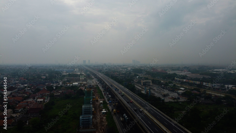 BEKASI, WESTJAVA, INDONESIA : JANUARY 10 202 : Aerial drone view of highway multilevel junction road with moving cars after rainy. Cars are blurred