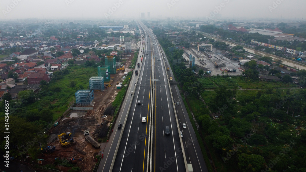 BEKASI, WESTJAVA, INDONESIA : JANUARY 10 202 : Aerial drone view of highway multilevel junction road with moving cars after rainy. Cars are blurred BEKASI, WESTJAVA, INDONESIA : JANUARY 10 202 : Aerial drone view of highway multilevel junction road with moving cars after rainy. Cars are blurred