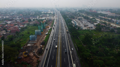 BEKASI, WESTJAVA, INDONESIA : JANUARY 10 202 : Aerial drone view of highway multilevel junction road with moving cars after rainy. Cars are blurred