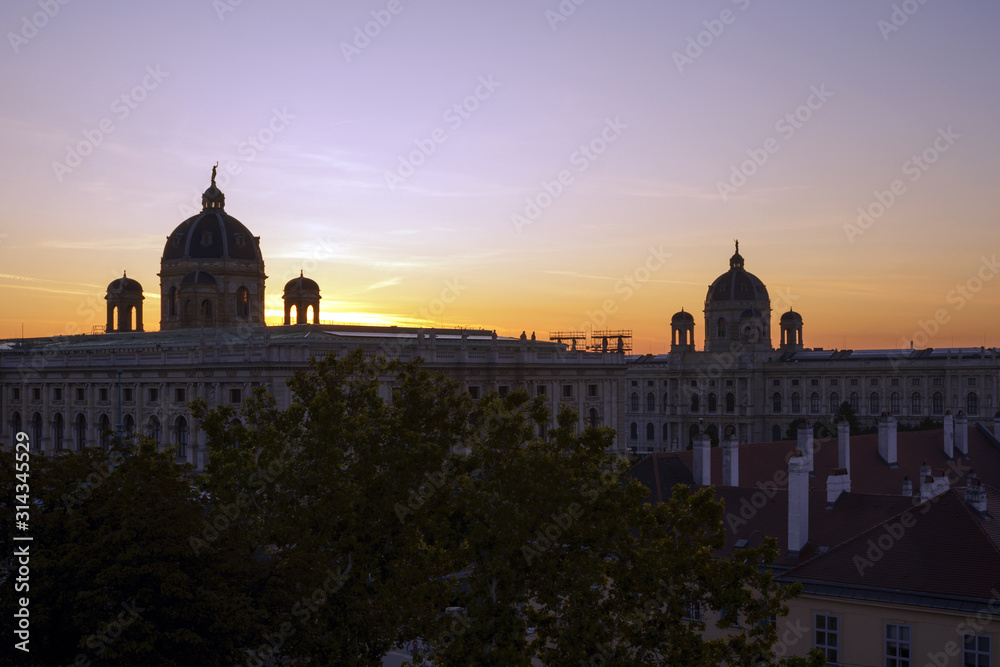 Sunrise in the city of Vienna, Austria. Domes of an old building in the rays of the rising sun. The beginning of a new day.