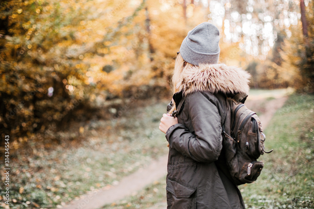 Hiking and travel along in the forest. Concept of trekking, adventure and seasonal vacation. Young woman walking in woods.