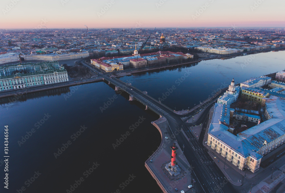 Fototapeta premium Beautiful aerial morning view of Saint-Petersburg, Russia, The Vasilievskiy Island at sunrise, Isaacs Cathedral, Admiralty, Palace Bridge, cityscape and scenery beyond the city, shot from drone