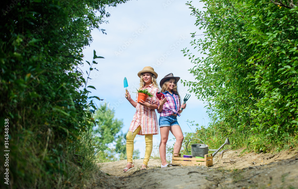 Beauty gardening. ecology and environmental protection. children hold gardening tools. earth day. summer family farm. small girls farmer in village. farming and agriculture. spring country side Beauty gardening. ecology and environmental protection. children hold gardening tools. earth day. summer family farm. small girls farmer in village. farming and agriculture. spring country side