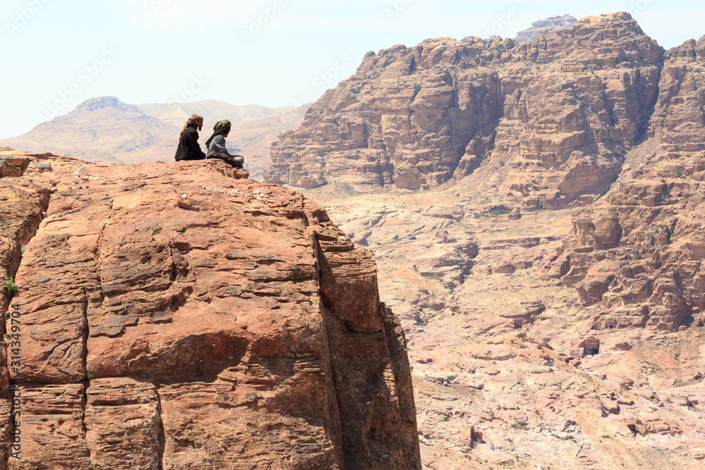 Typical Bedouins sitting on rock at High place of sacrifice in ancient city of Petra in Jordan Typical Bedouins sitting on rock at High place of sacrifice in ancient city of Petra in Jordan