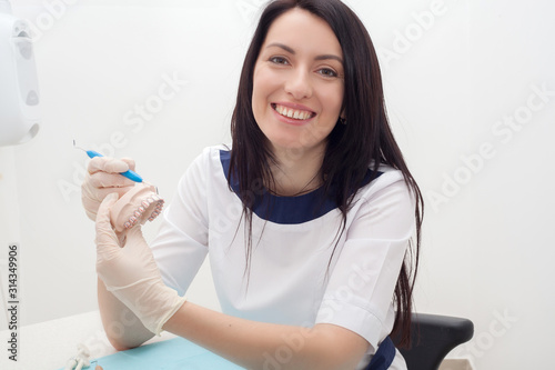 The dentist on the artificial jaw demonstrates caries, as well as the location of the teeth. The concept of oral health.