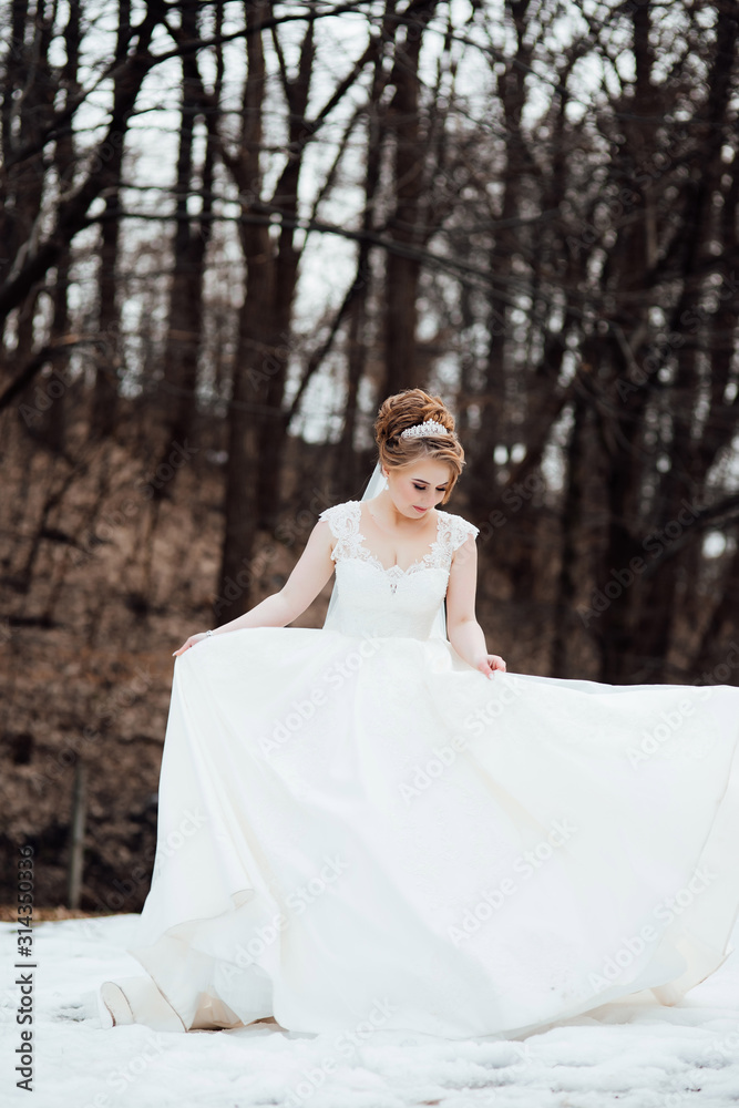 Beautiful sensual young bride in white wedding dress and veil standing in autumn outdoor on natural background. Wedding. Magic photo. The bride is spinning. Lovely dress. Beauty woman