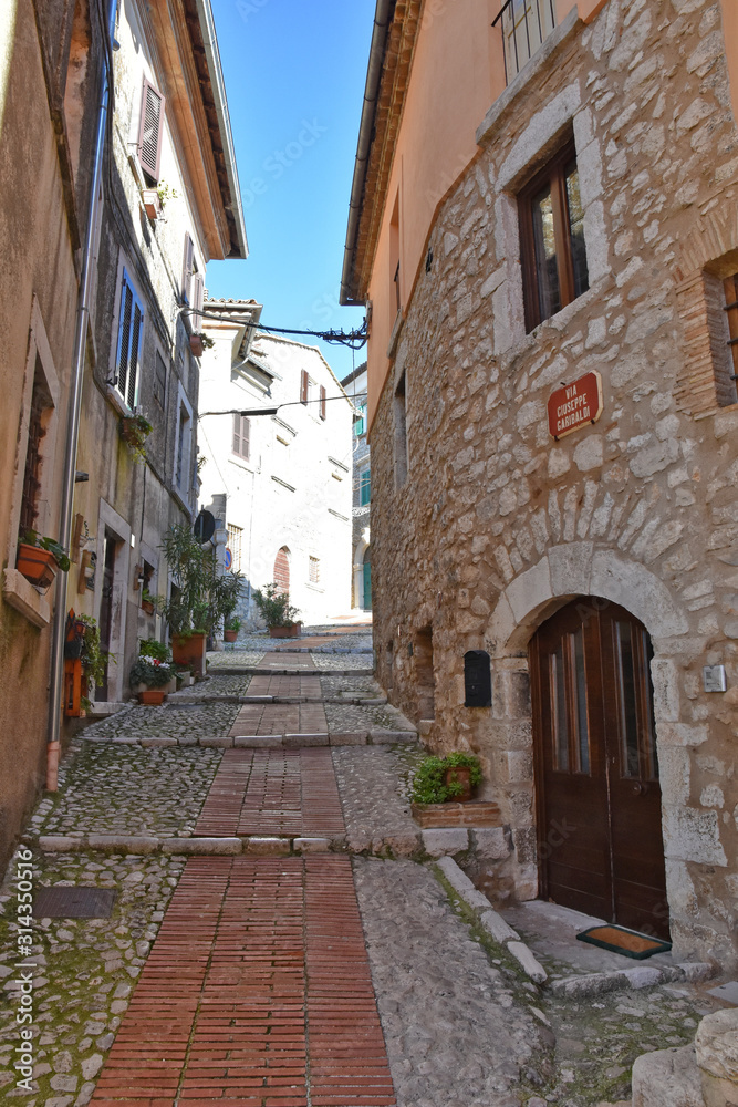 A narrow street between the old houses of a medieval town in Italy