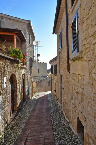Fototapeta Naklejka Na Ścianę i Meble -  A narrow street between the old houses of a medieval town in Italy