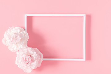 Beautiful flowers composition. Blank frame for text, pink flowers on pastel pink background. Valentines Day, Easter, Birthday, Mother's day. Flat lay, top view, copy space