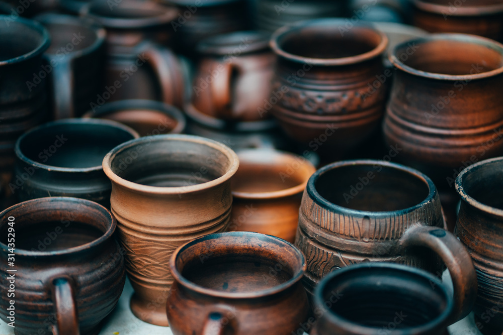 Beautiful clay pots of different shapes on the counter. Pottery workshop products.