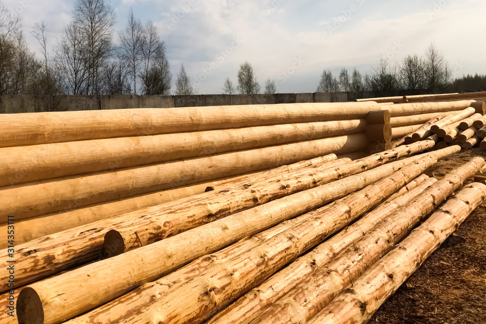 Drying and assembly of wooden log house at a construction base.