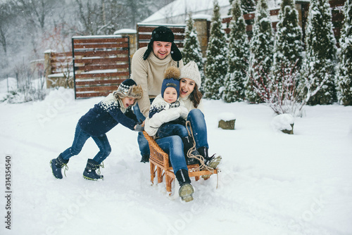 Obraz na plátně Happy Family sledging outside in winter. Winter time.