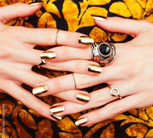 woman hands with golden manicure lot of jewelry on fancy dress closeup beauty concept photo