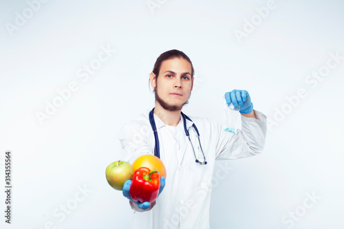 young pretty doctor with stethoscope holding fruits, vegetables and pills, healthy food care concept