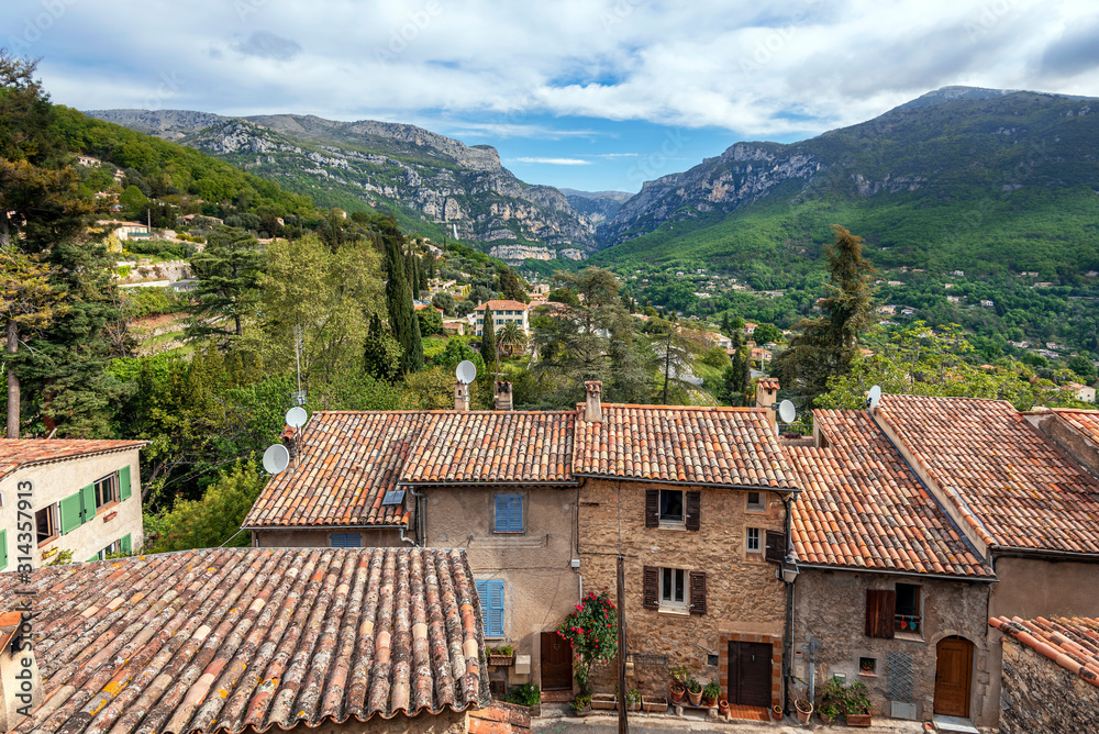 The Loup gorge as seen from the Church square of Le Bar-sur-Loup village in Southeastern France. Facades and roofs of old village houses are at foreground.