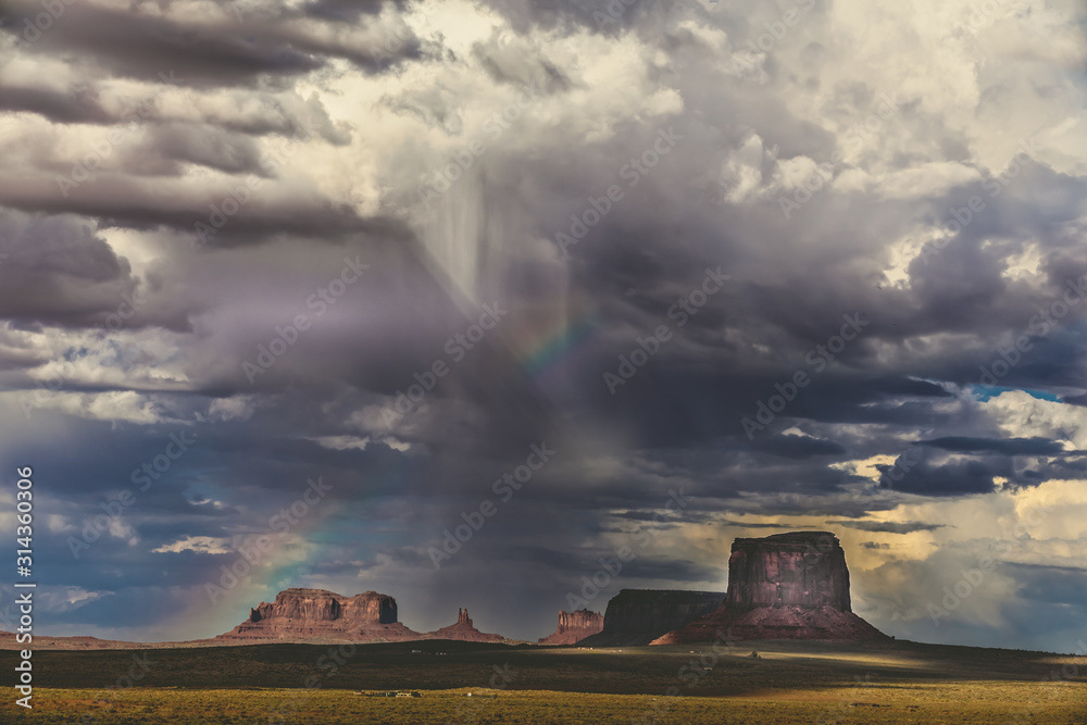 Dramatic clouds, rain and a rainbow over Monument Valley