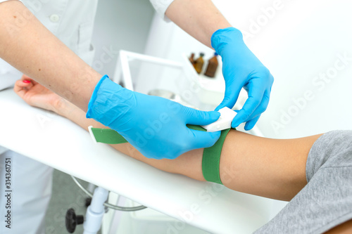 the nurse fastens the clip on the patient hand before the blood sampling procedure.