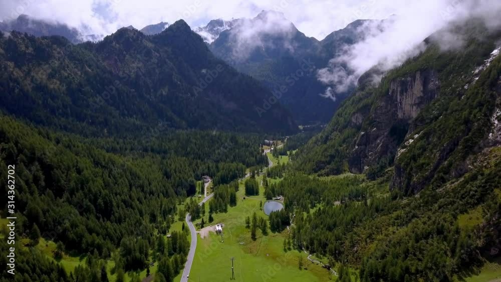 Dolomite peaks in northern Italy with a grassy canyon below on a clear winter day, Aerial drone approach