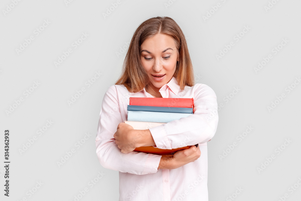 Freestyle. Young woman student standing isolated on white with books looking down surprised Freestyle. Young woman student standing isolated on white with books looking down surprised